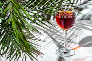Savor the rich flavors of a red cocktail featuring scotch whisky, sherry, and liqueur, with lush...