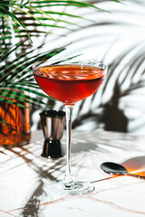 Red cocktail with whiskey, port wine, amaro, and bitters served in an elegant glass at a stylish bar lounge