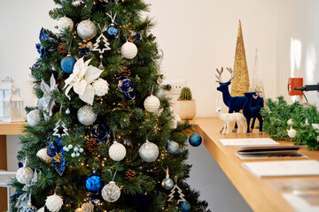 Elegant christmas tree with blue and silver decorations in cozy setting