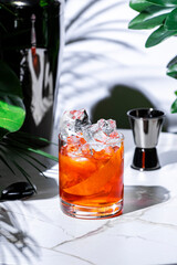 Non-alcoholic negroni mocktail with ice served in a stylish bar setting