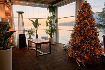 Cozy seaside balcony with christmas tree at sunset
