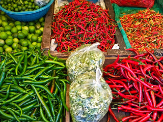 A vibrant display of fresh chilies and limes at a traditional market. The bold colors and rich textures capture the essence of local culinary culture,