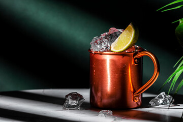 London mule alcoholic cocktail drink with gin, lime juice and ice. Green background, hard light