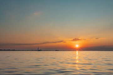 Boat sailing alone on Lake Constance, lonely sailing ship waiting for the sunset in the golden...