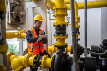 An engineer is inspecting a pressure motor pump and checking a gas pipeline pressure gauge