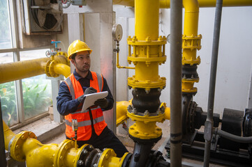 An engineer is inspecting a pressure motor pump and checking a gas pipeline pressure gauge