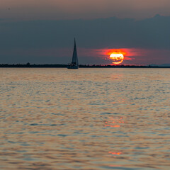 Sunset with sailing ship, boat on Lake Constance, red and orange sunset above the waves on the...