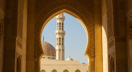 Framed view of a historical mosque tower with detailed archways in light tan hues showcasing oman