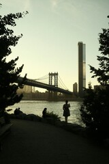 Manhattan Bridge Sunset: Serene NYC Riverbank Silhouette