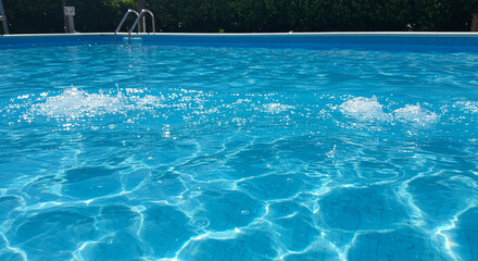 Dynamic blue pool water with sunlit ripples and splashing surface texture on a bright day
