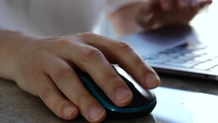 Using a computer mouse for a laptop at a desk.
An office worker at a computer clicks a digital wireless mouse with his finger.
A programmer works at a laptop - Powered by Adobe