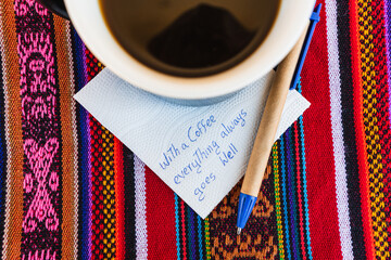 Coffee cup with a written note that says With a cup of coffee everything always goes well, on a...