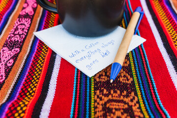 Coffee cup with a written note that says With a cup of coffee everything always goes well, on a...