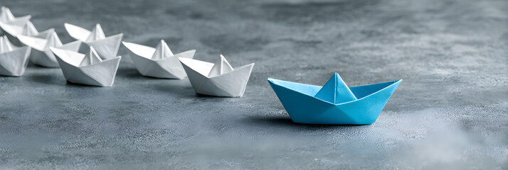 Blue Paper Boat Leading A Fleet Of Small White Boats With Compass Icon On Grey Concrete -...