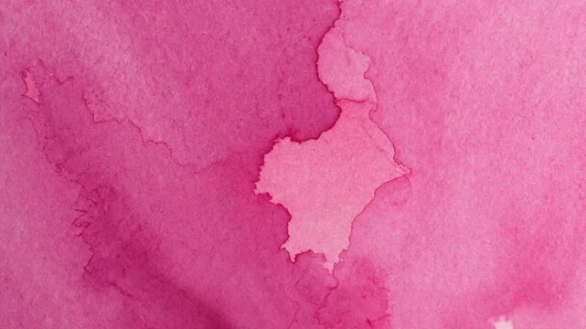 A closeup view of pink watercolor on textured paper revealing tonal variations and distinct watercolor marks