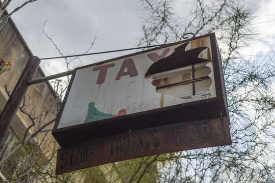 View of a weathered, rusted sign with peeling paint and broken letters, evokes a sense of decay and forgotten history, Varosha, Famagusta, Cyprus.