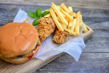   Home made  chicken Burger and   deep fried french fries on wooden   cutingboard 