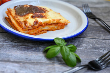   Delicious Home made Lasagna  with minced meat,tomato sauce and spinach  on a wooden rustic ...
