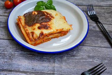   Delicious Home made Lasagna  with minced meat,tomato sauce and spinach  on a wooden rustic  background.Home made italian meal