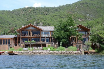 House on the Lake. Traditional Chinese wooden lakeside house, balconies, large glass windows,...