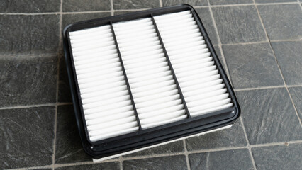 Top view of new engine air filter of car. Cloth panels are covered with clean white. Placed on a...
