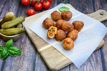 Mini cheese  burger balls.  Ball shaped snack with meat, pickled cucumbers and tomato on wooden...