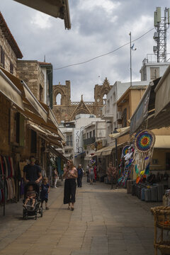 Lefkosia, Cyprus - 25 June 2025: View of a bustling street scene with the striking silhouette of the Selimiye Mosque against a cloudy sky.