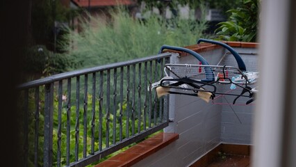 Wet balcony railing and hangers during summer rain