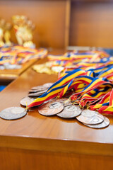 Bronze medals with colorful ribbons laid out on a table, ready for distribution.