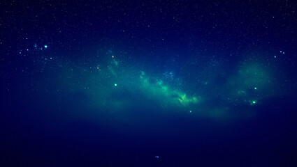 Obraz premium Vast starry night sky with glowing green nebula and distant stars