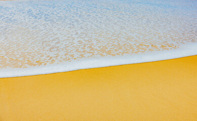 Schaum vom Meer an einem Sandstrand