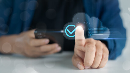 Hand tapping cloud verification icon on digital interface, symbolizing data approval, cloud storage, and secure digital process in business technology.