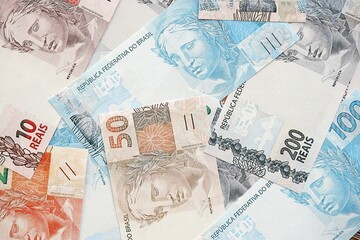 Brazilian reais banknotes. The current Brazil real money bills lies on table in big amount