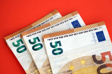 Big amount of european euro currency money notes on red color table close up