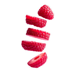 Sliced raspberries suspended against black background