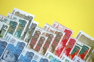 Pakistan rupees banknotes on yellow background. The current Pakistan money bills