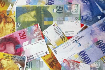 Swiss franc banknotes. The current francs money bills lies on table in big amount