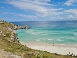 Fototapeta premium Praia Grande (Big Beach) Arraial do Cabo, Rio de Janeiro - Brazil: sunny morning, coastal atmosphere of the winter, white sand and crystal-clear blue waters in Brazilian Caribbean.