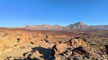 The breathtaking views of rocky terrain and majestic mountains are truly aweinspiring beneath a clear blue sky