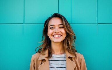 An eye-catching stock photo of casual portrait of smiling woman in front of aqua wall, ideal for creative, commercial, or editorial purposes. High quality