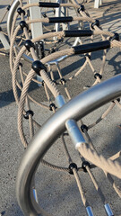 Modern playground climbing net structure and bike rack in a green city park at sunset. Urban recreational area for children and adults