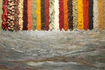 Many different spices on textured table, flat lay. Space for text