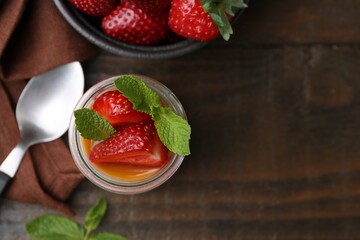 Tasty panna cotta with caramel, strawberries and mint on wooden table, flat lay. Space for text