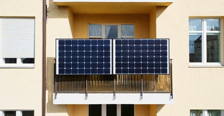 Black solar panels installed on a balcony of a residential building. Eco-friendly energy solution for urban homes in the modern city, renewable power source.