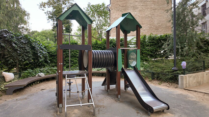 Modern playground climbing net structure and bike rack in a green city park at sunset. Urban recreational area for children and adults