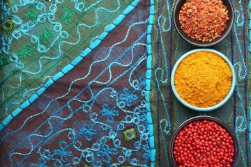 Different aromatic spices on blue tablecloth, flat lay. Space for text