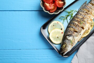 Homemade seafood dish. Tasty roasted seabass fish with spices and tomatoes on light blue wooden...