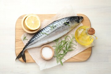 Fresh raw mackerel and spices on light wooden table, flat lay. Seafood delicacies