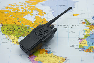 Communication device rests on a world map highlighting locations across different continents and...