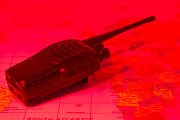 Red toned communication device placed on a world map illustrating global connectivity and...
